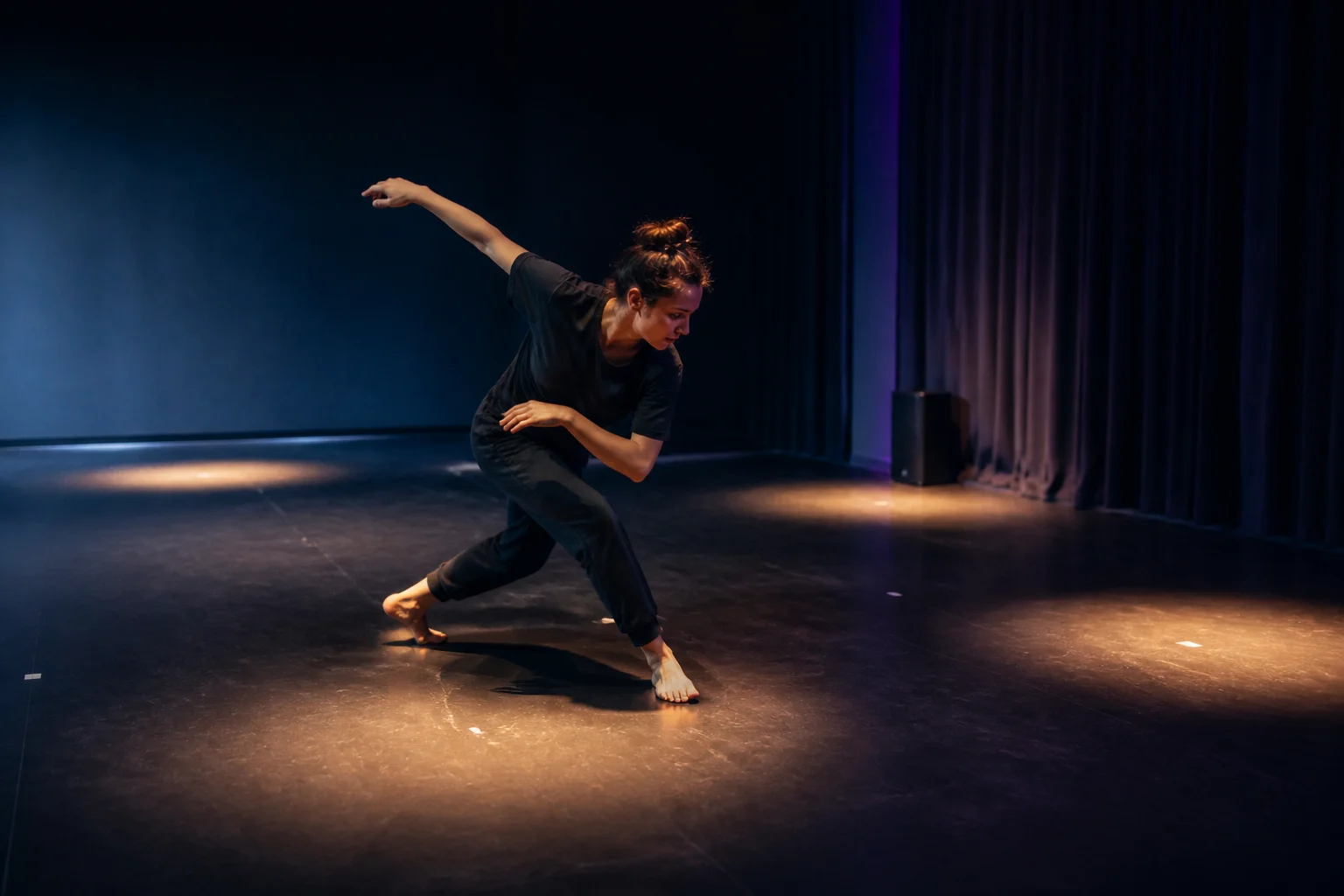 Movement creator rehearsing a precise sequence as light and electronic pulse change across the studio
